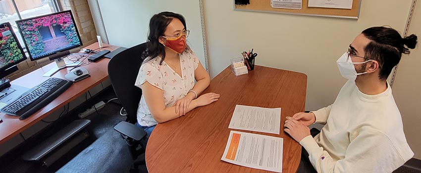 Advisor and student talking in office.