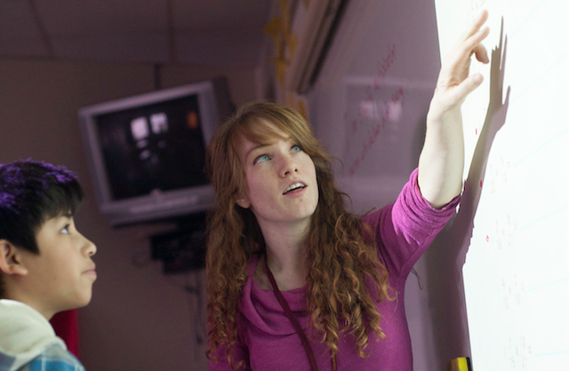 Teacher pointing to overhead projector screen.